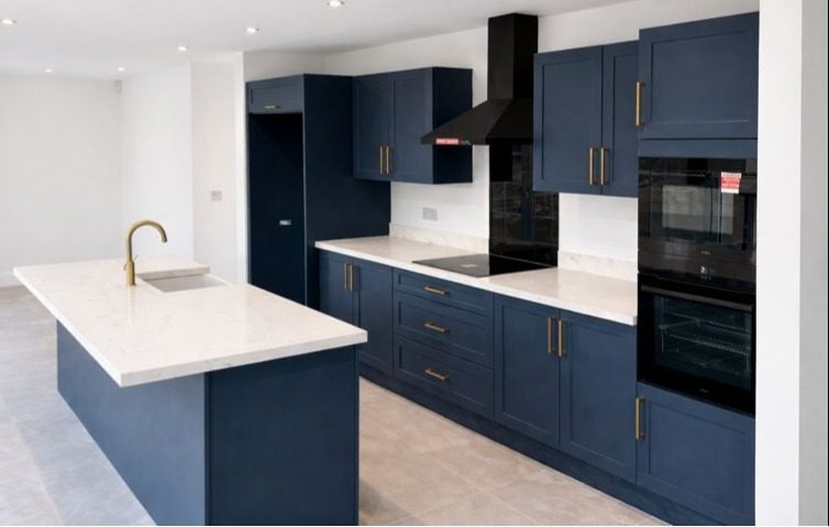 Indigo blue shaker kitchen Essex - Navy shaker style island kitchen with brass handles and quartz worktops