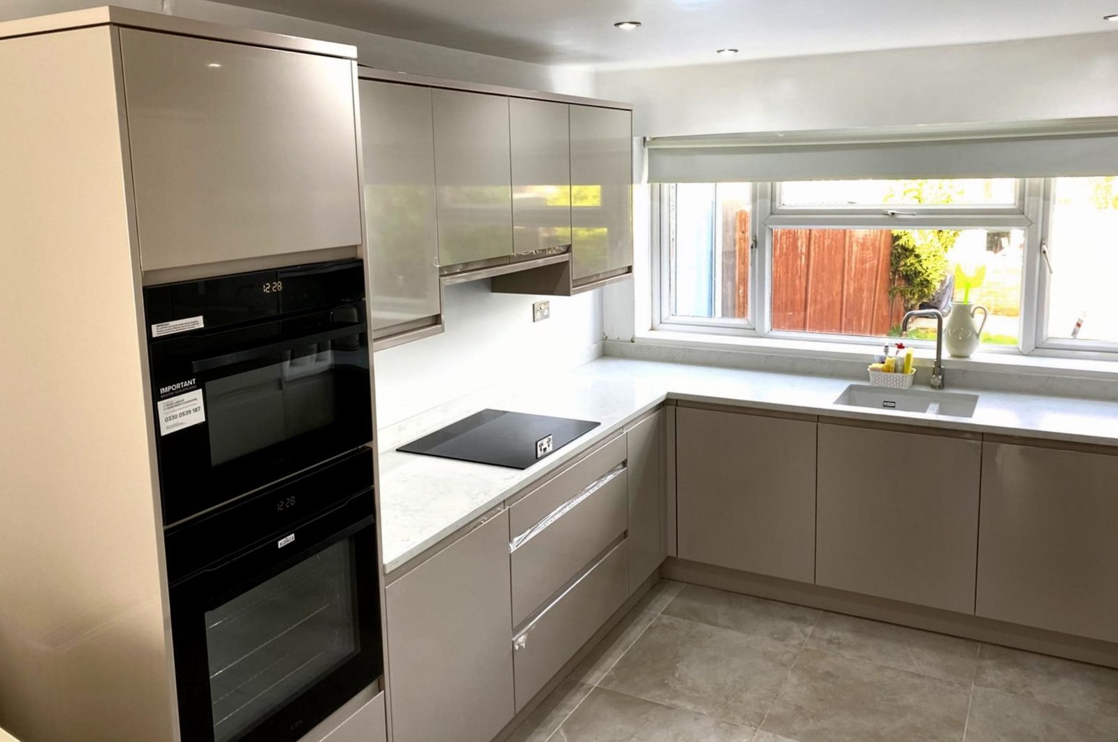 Mussel gloss handleless kitchen Hertfordshire - Contemporary handleless kitchen with quartz worktops and integrated appliances