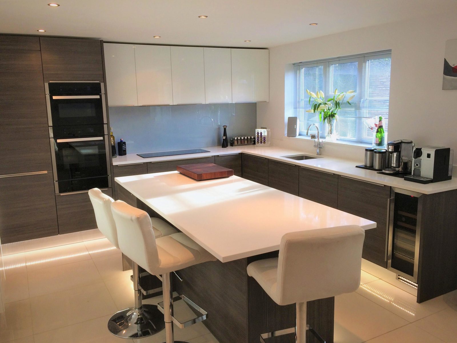 Slab kitchen installation Essex - Dark woodgrain slab kitchen with white gloss uppers and island