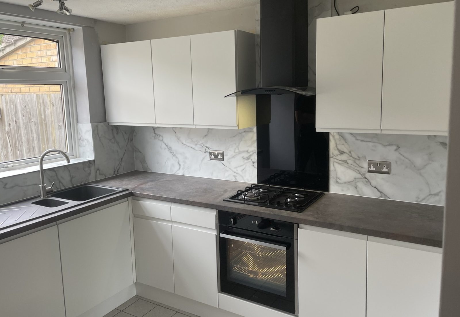 White handleless kitchen installation - Matt white handleless kitchen cabinets with integrated appliances